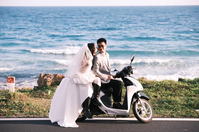 Mạnh và Hằng bên chiếc xe máy trên con đường ven biển